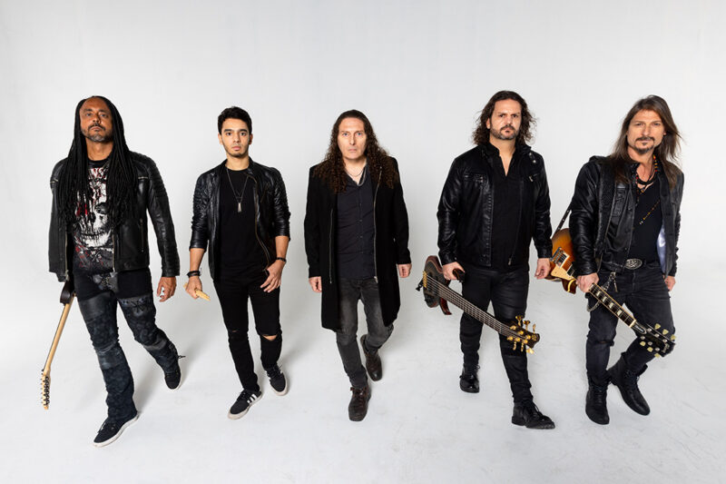 Bild på fem medlemmar i bandet Angra mot en vit fotobakgrund.