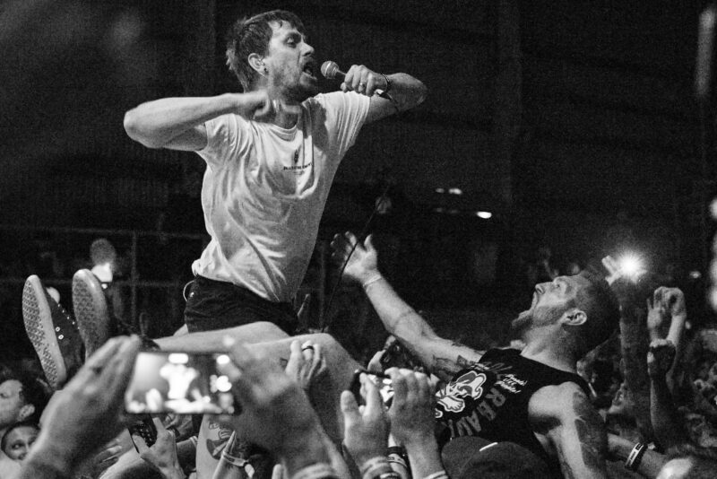 Svartvit bild på sångaren i Blindside som surfar uppe på publiken.