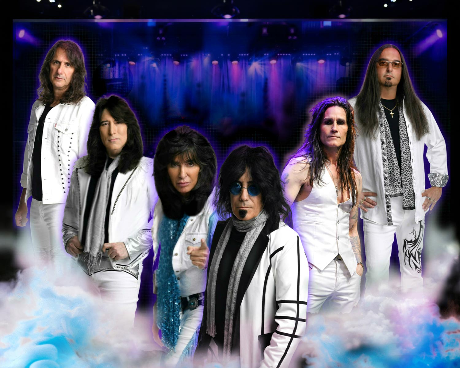 The members of the Angel pose in white stage outfits in front of a concert stage.