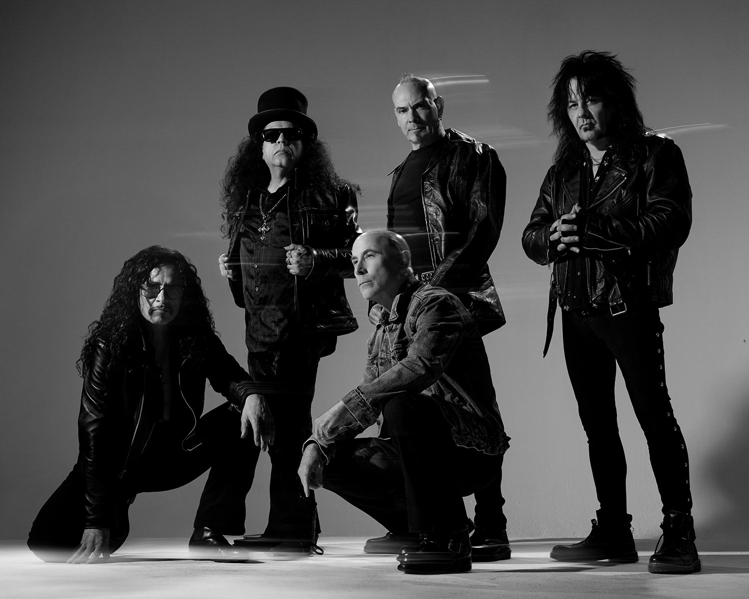A black-and-white photo of five band members dressed in black.