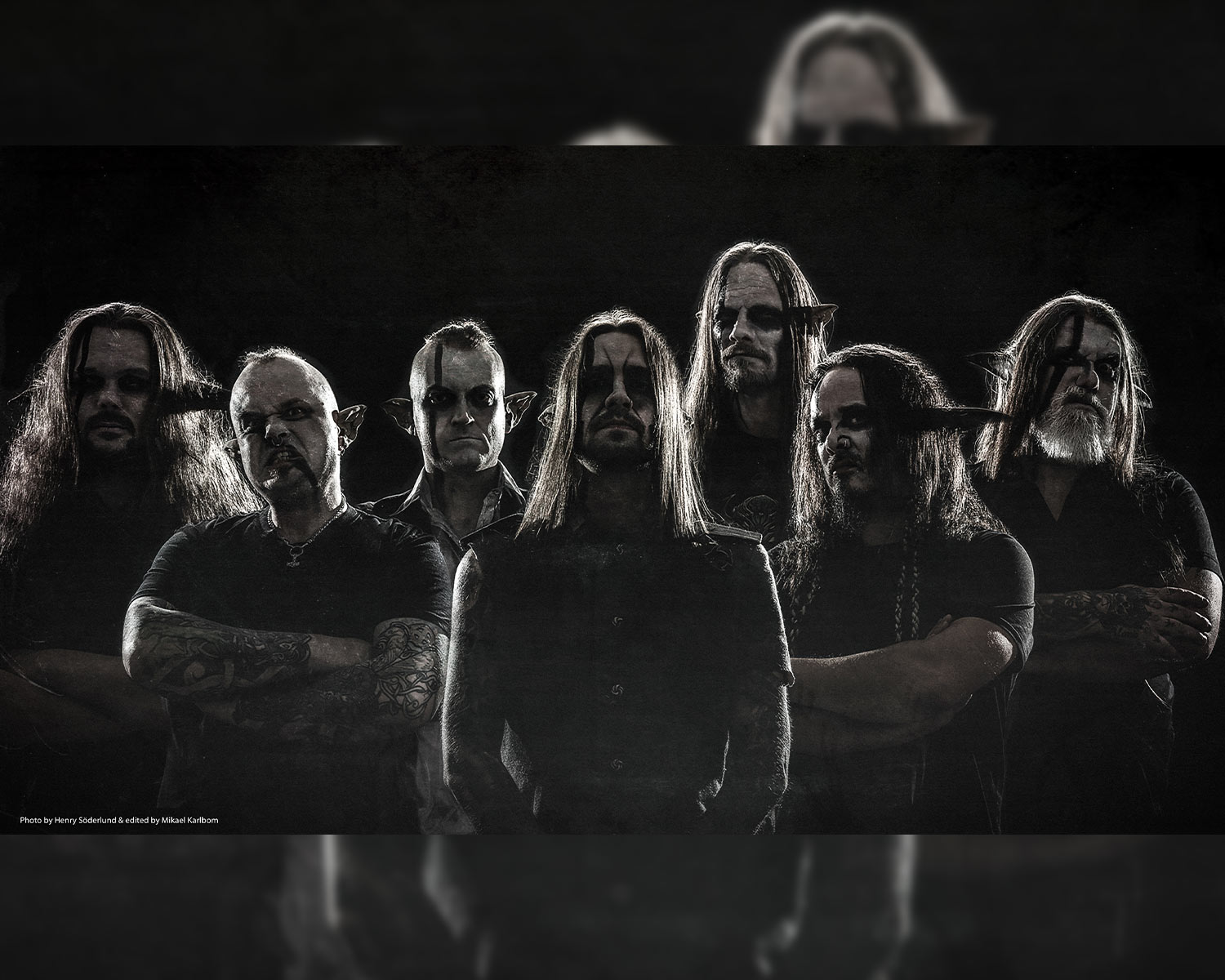 The members of Finntroll pose together in black and white against a dark background.