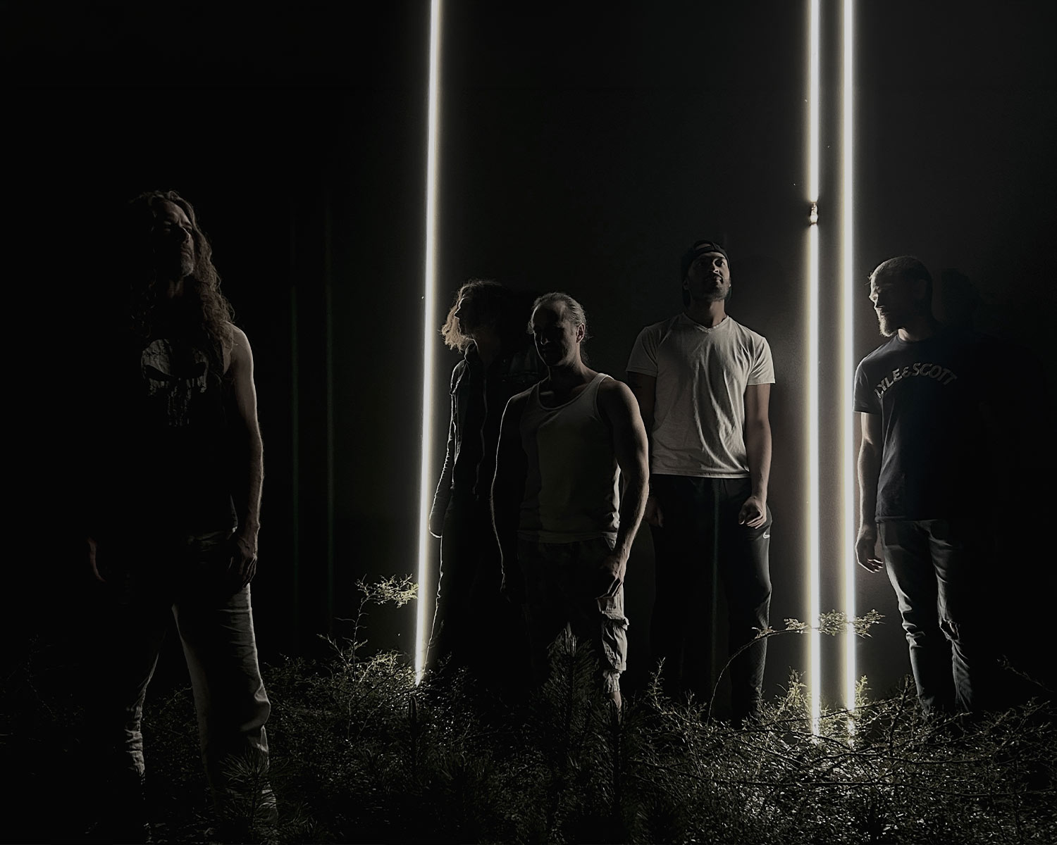The members of Pain of Salvation stand in the darkness between tall, vertical fluorescent lights.