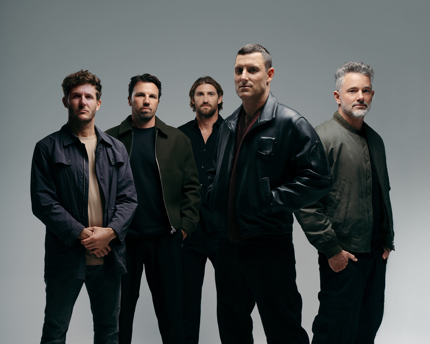 The members of Parkway Drive pose against a bright background.