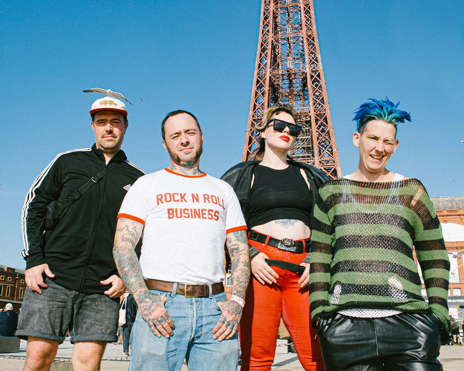 The members of Split Dogs pose together under a blue sky.
