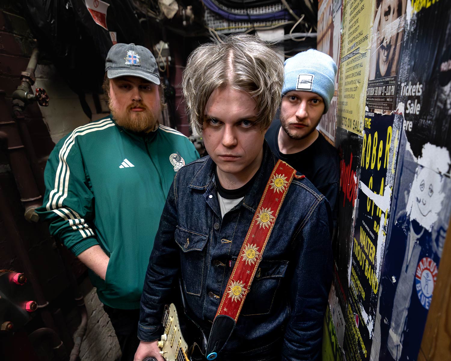 The members of The Zac Schulze Gang are standing in a narrow hallway, with the guitarist in the foreground.